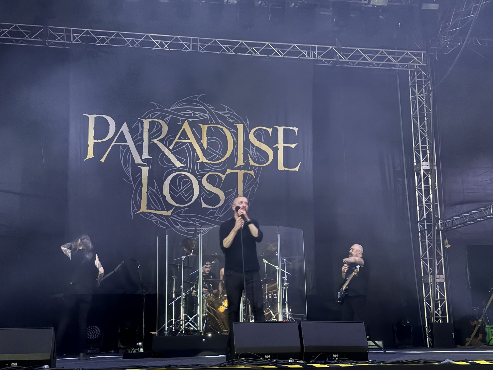 Paradise Lost on stage in front of their logo